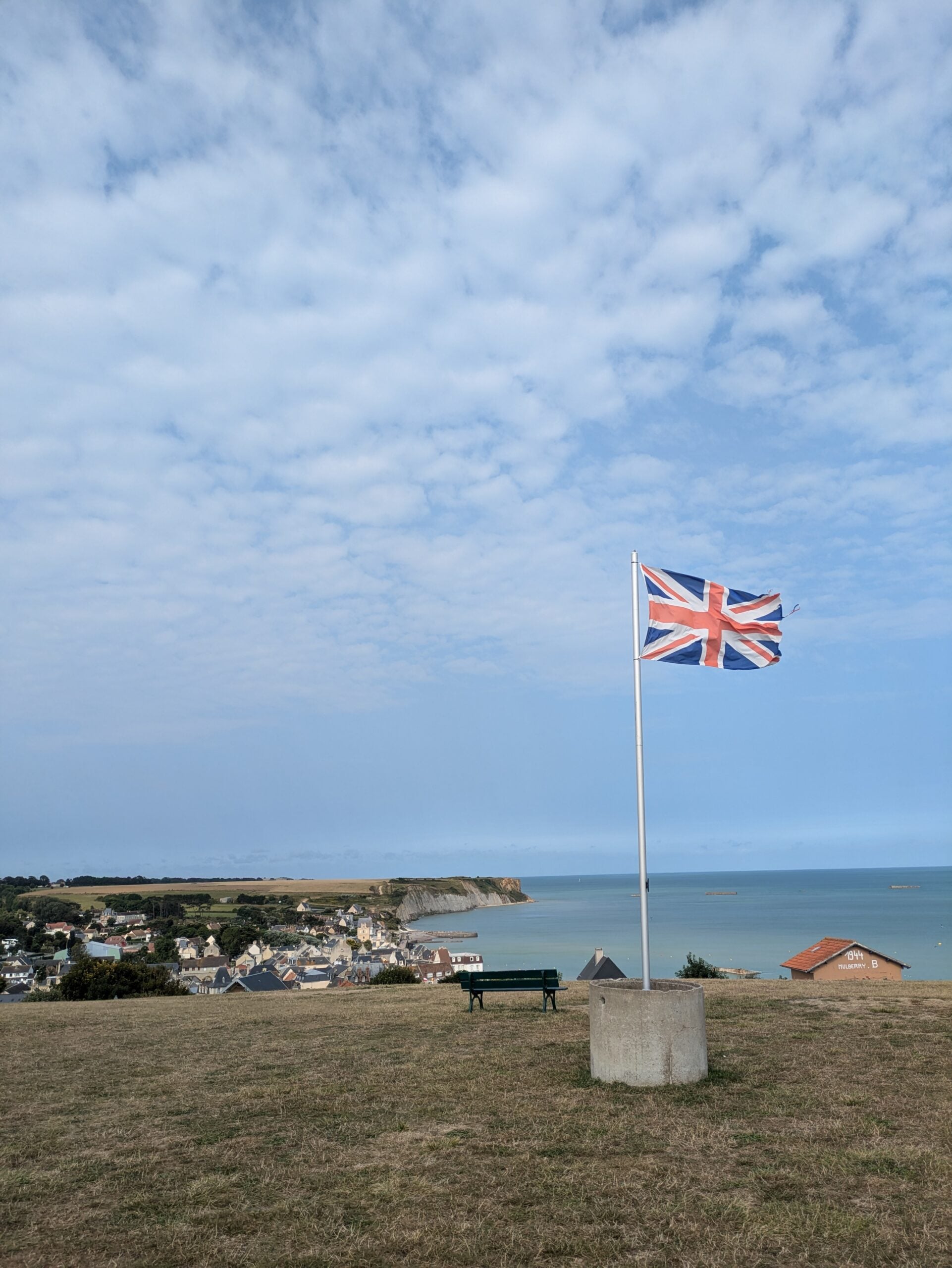 british flag flying above gold beach at arromanches